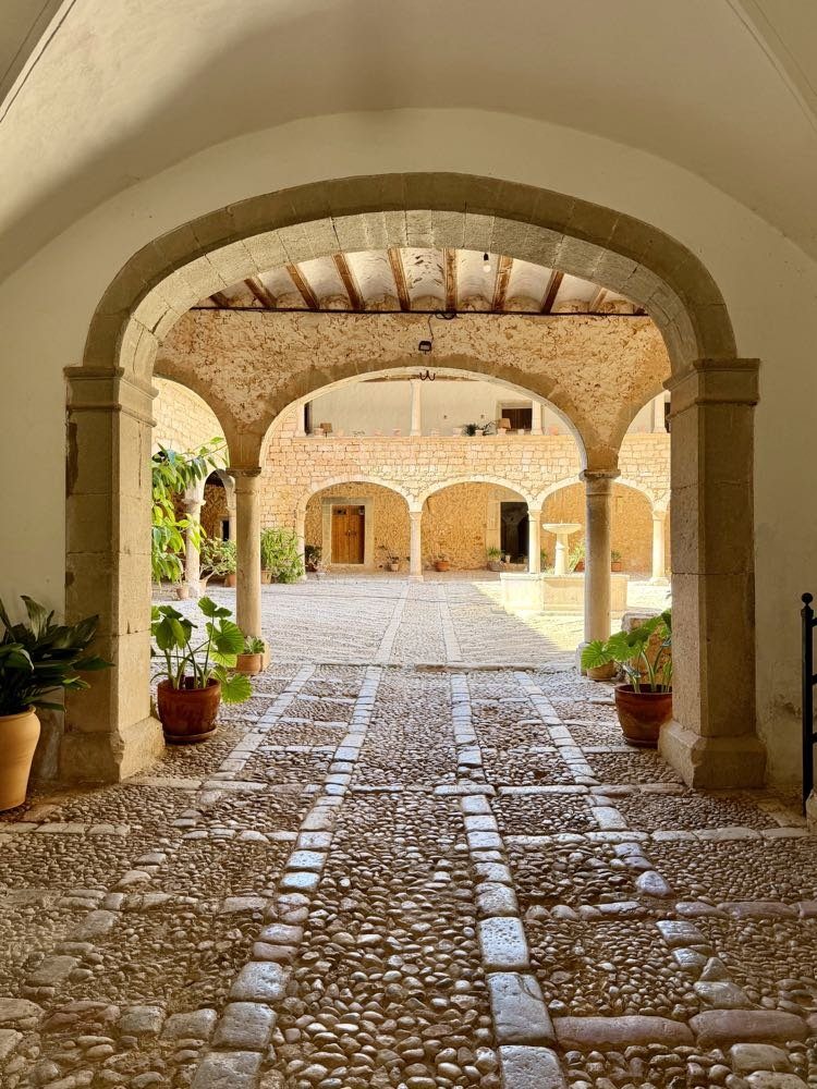 Stone arches opening onto the courtyard of a historic palacio on Mallorca